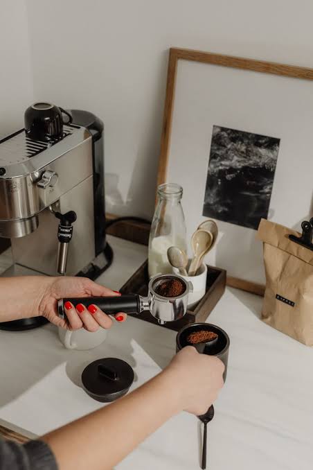 Barista vertiendo leche sobre una preparación de café